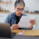 femme lisant avec surprise un courrier, relevé de banque, expulsion, lettre recommandée