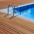 blue swimming pool with teak wood flooring