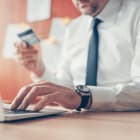 Businessman completing e-banking transaction using laptop computer and credit card