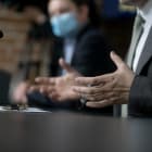 Hands of an official, speaker or boss during a press conference – meeting with the press. Speaker at the talks. Blank plate to indicate the name and position. Close-up. No face