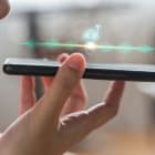 Close up of pretty woman holding in hand smart phone talking wit