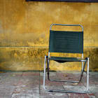 Vintage fabric chair placed in front of yellow wall, Vietnam, Hoi An