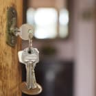 Clés sur une porte entrouverte.