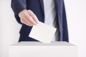 Main mettant un bulletin de vote dans une urne