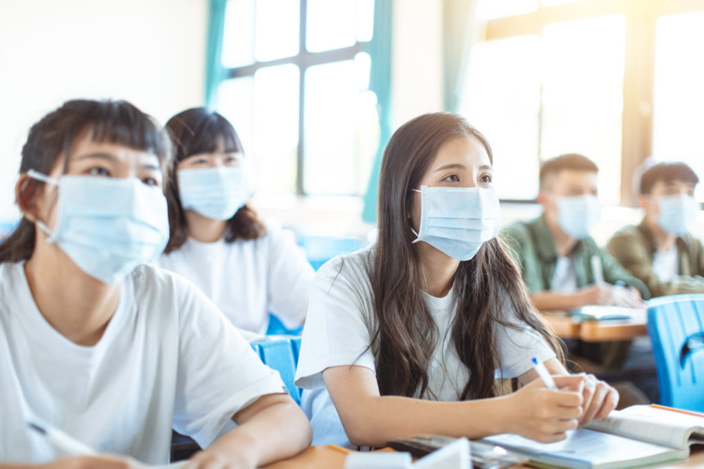 Photo d'étudiants ou lycéens en classe portant un masque chirurgical contre le Covid