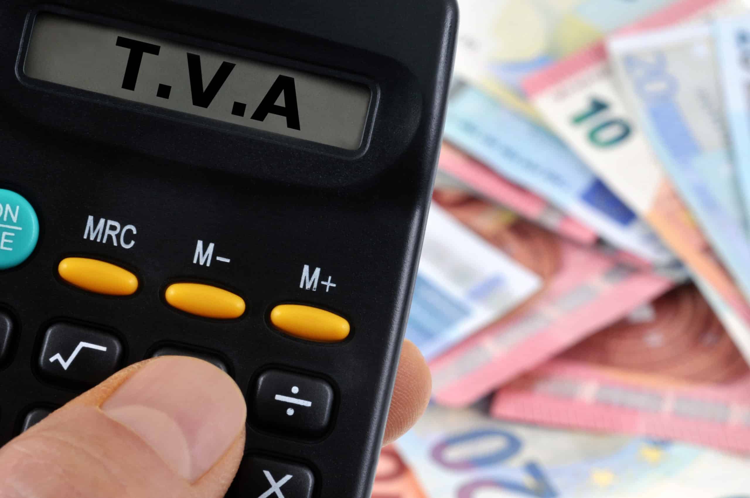 Photo d'une calculatrice avec indiqué sur l'écran TVA sur fond de billets euros