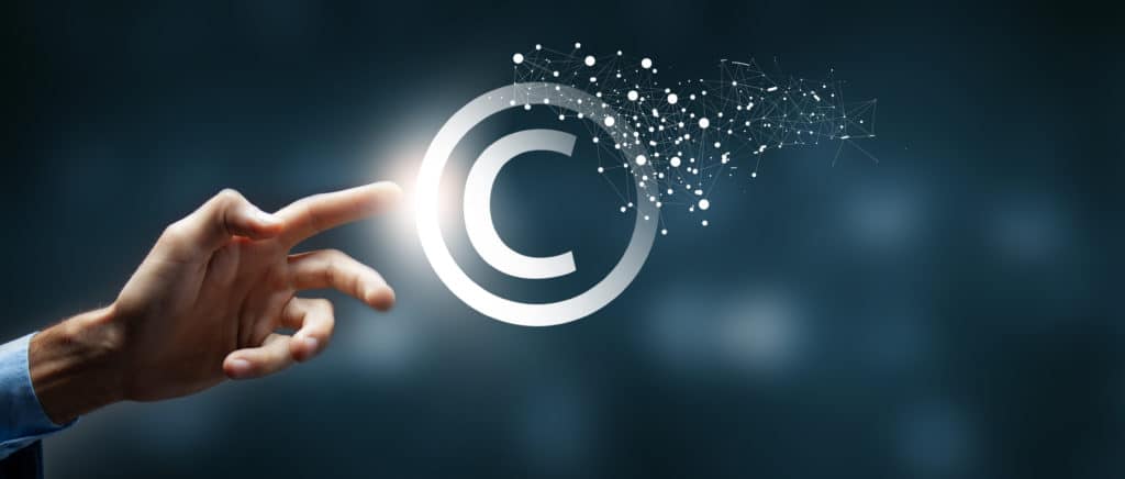 Main qui touche du bout de l'index le signe virtuel du copyright