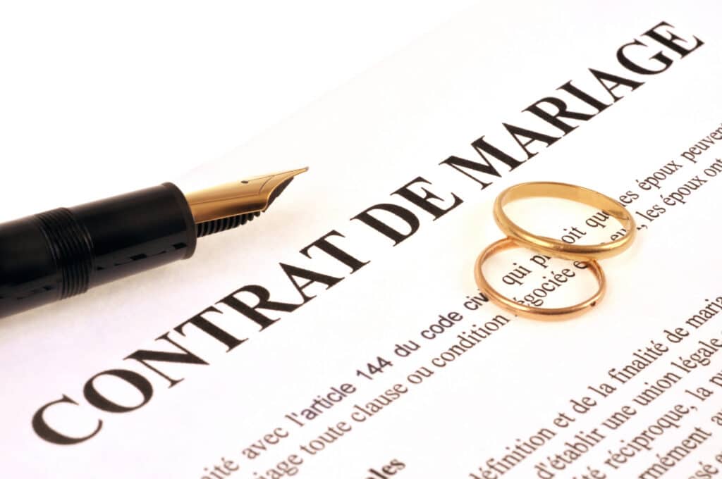 Alliances et stylo plume sur un contrat de mariage