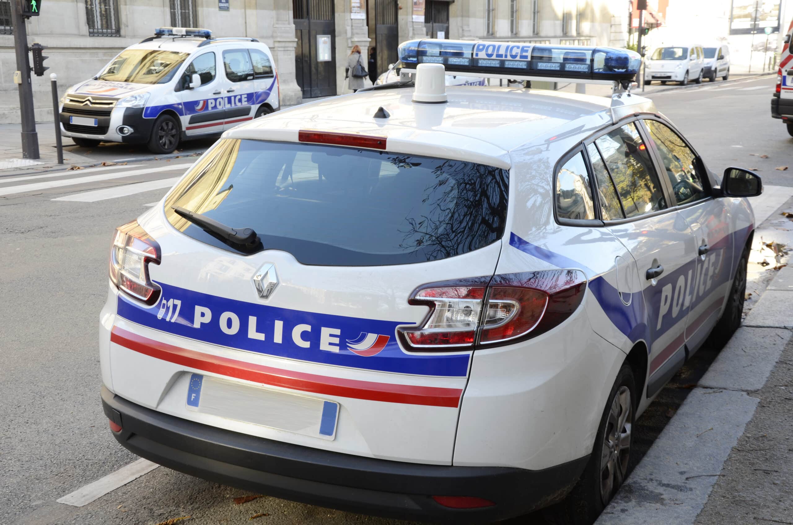 Voitures de police garées dans la rue.