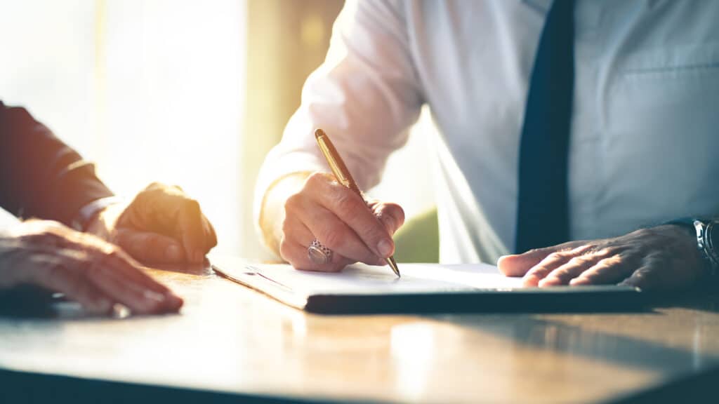 Homme signant un contrat sur une table