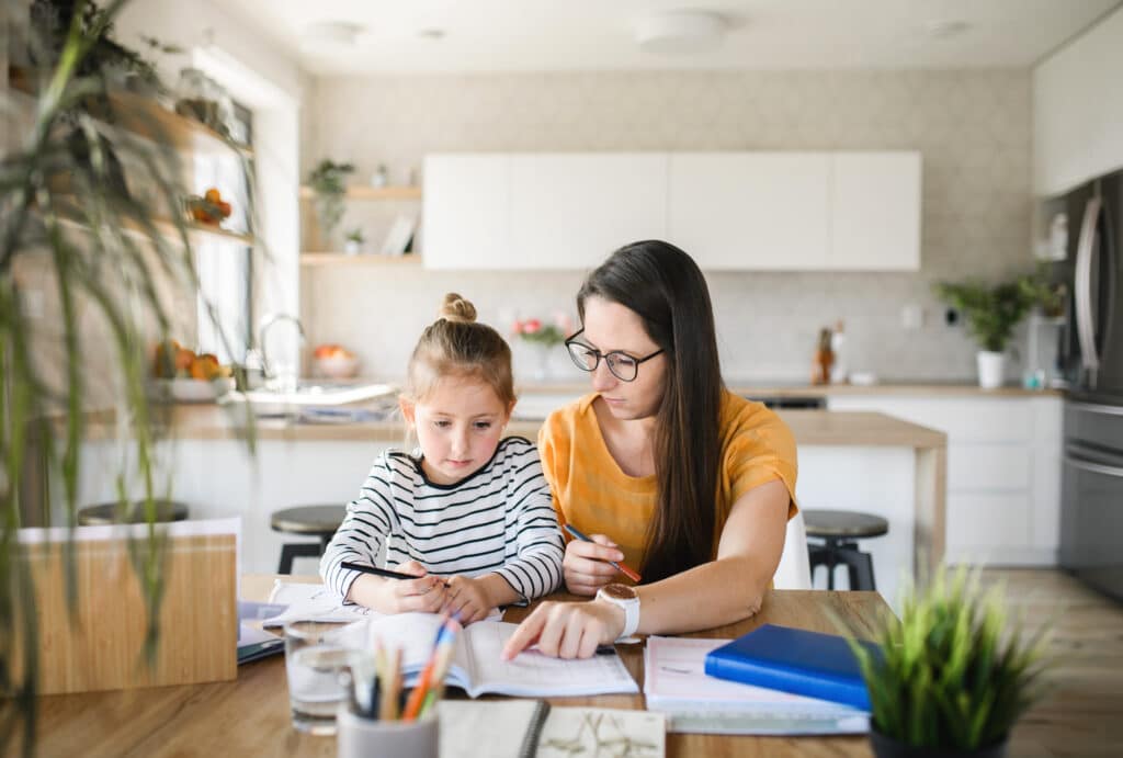 Une mère faisant travailler sa fille sur la table de la salle à manger, image conceptuelle de l'école à la maison