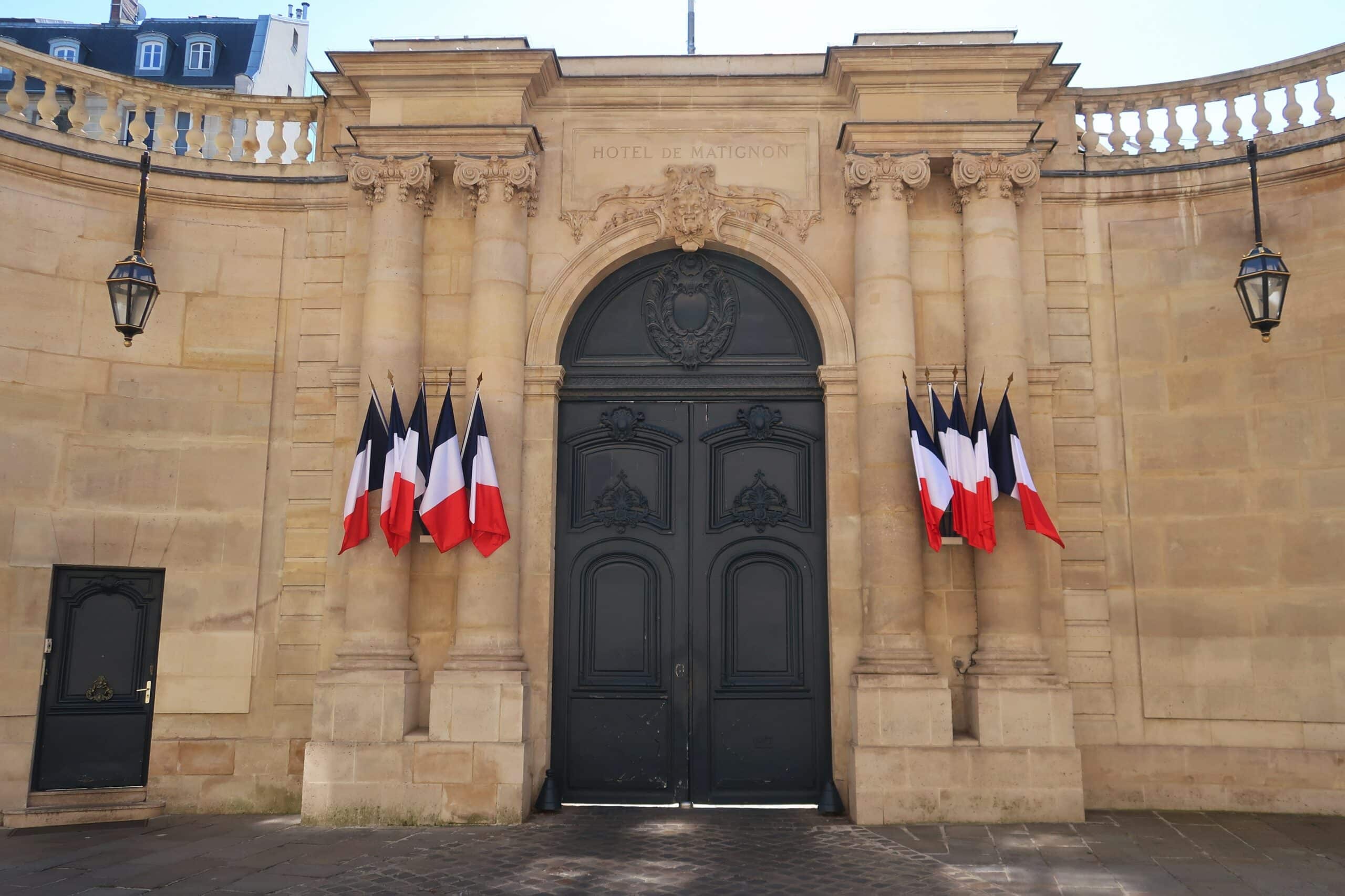 Portail d'entrée de l'hôtel de Matignon, palais de résidence officielle du Premier Ministre français, rue de Varenne à Paris, avec plusieurs drapeaux français (France)