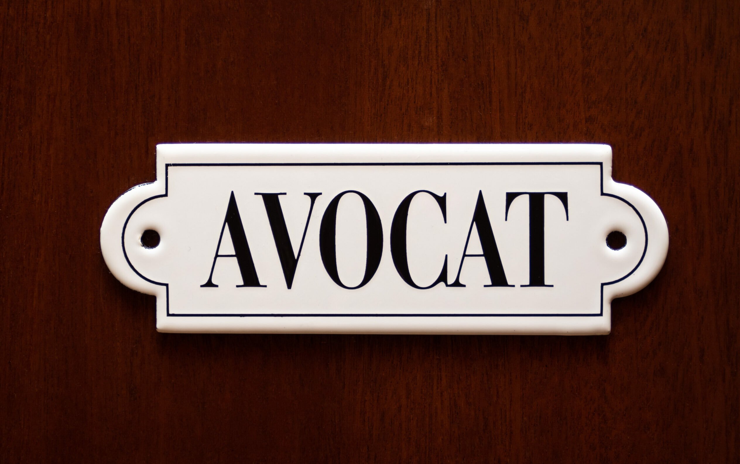 A closeup on door with lawyer name Avocat in french. Concept of lawyer services.