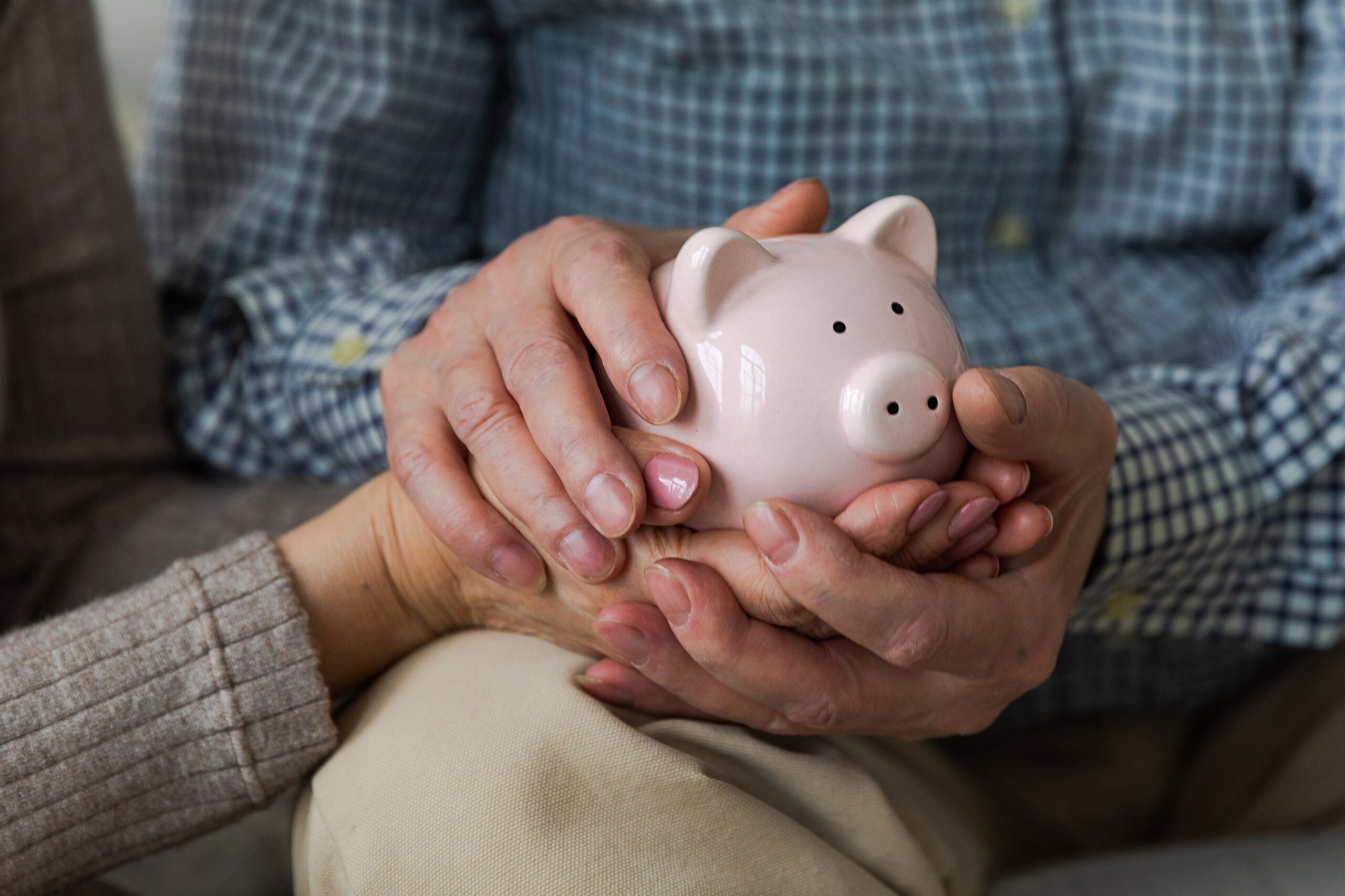 Saving money investment for future. Senior adult mature couple hands holding piggy bank with money coin. Old man woman counting saving money planning retirement budget. Investment banking concept.