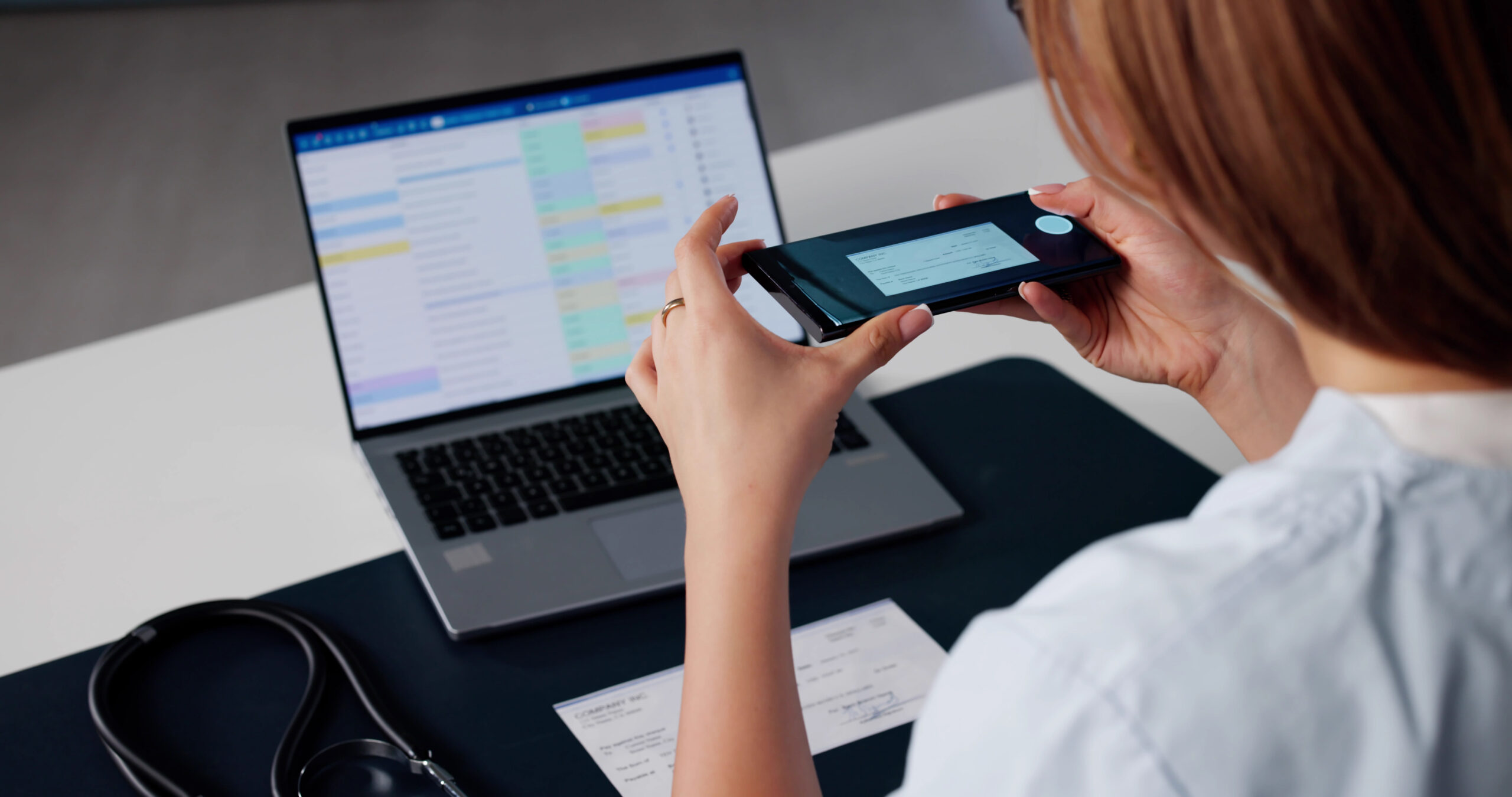 Infirmière prenant un chèque en photo avec son smartphone